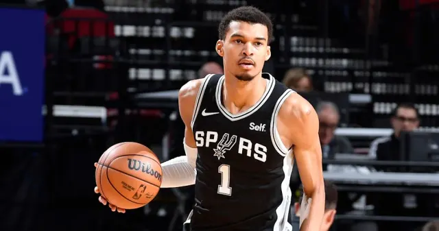 Victor Wembanyama, siyah San Antonio Spurs formasıyla top sürüyor