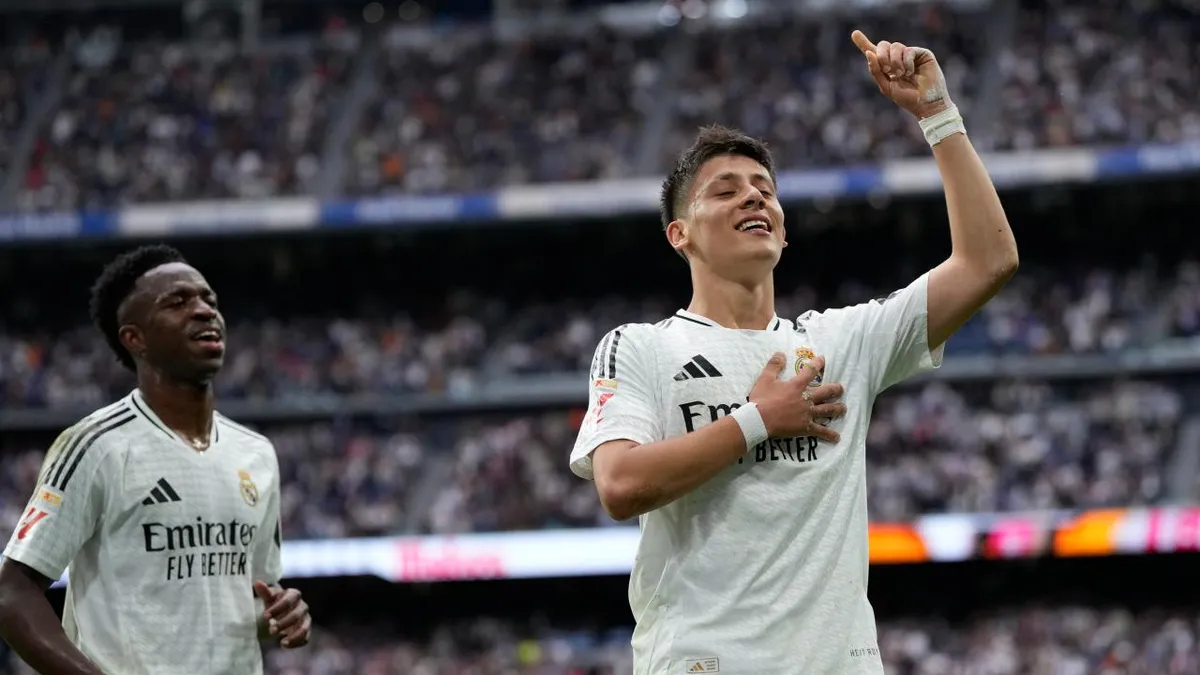 Real Madrid formasıyla Arda Güler, attığı golün ardından eli göğsünde ve parmağı havada sevinirken; arkada Vinicius Junior