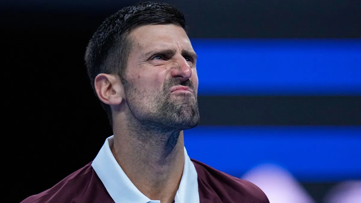 Novak Djokovic, maç sırasında yüzünü buruşturarak yukarı bakıyor