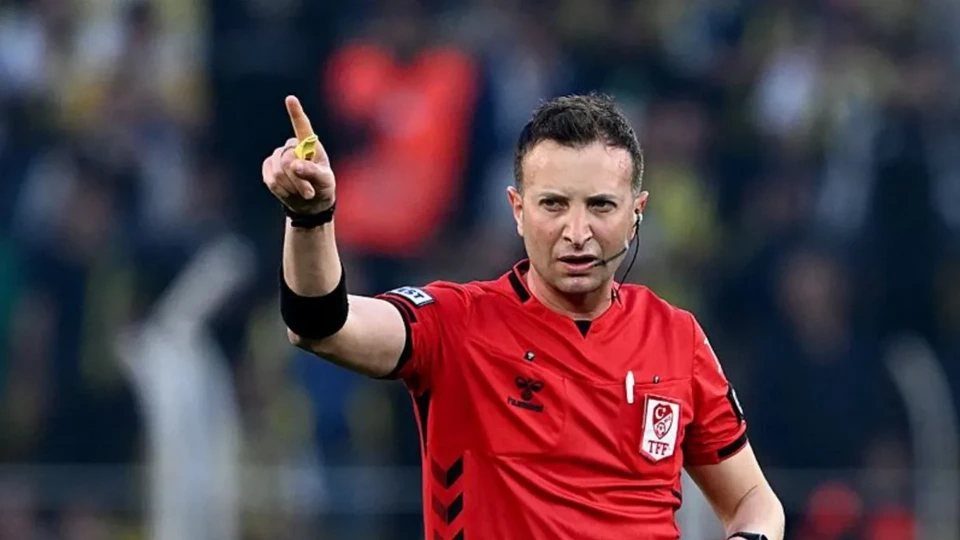 Hakem Yasin Kol, bir Süper Lig maçında kırmızı hakem formasıyla eliyle işaret verirken