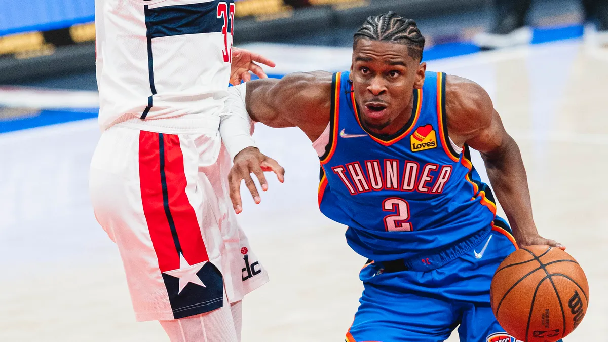 Shai Gilgeous-Alexander, 2 numaralı mavi Oklahoma City Thunder formasıyla topu sürerek rakibin yanından geçiyor