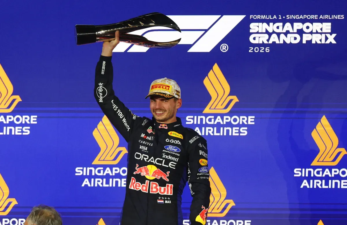 Max Verstappen Singapur Grand Prix podyumunda kazandığı kupayı havaya kaldırıyor